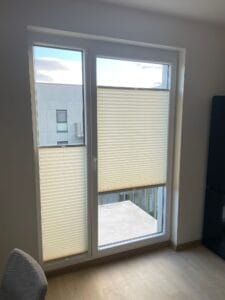 Jasne plisy na wymiar zamontowane w drzwiach balkonowych – realizacja Veo Design Łódź